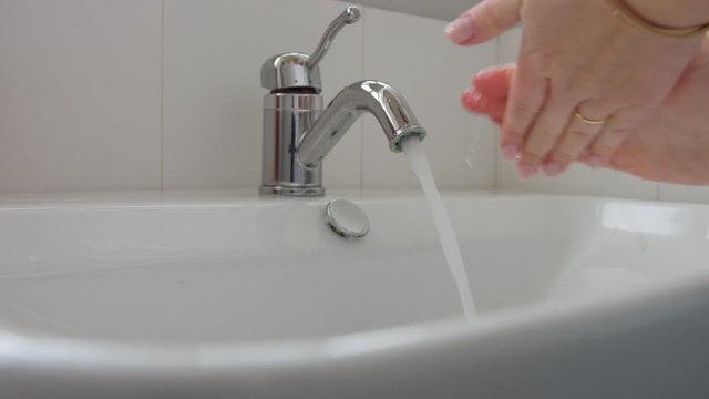 female hands closeup washing in home bathroom full of daylight. Hygiene norms concept