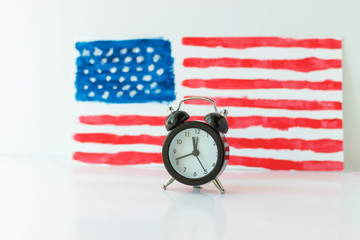 Alarm clock and abstract hand drawn American flag on background. President elections, Memorial Day,...