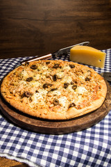 pizza with cheese and olives on wooden board