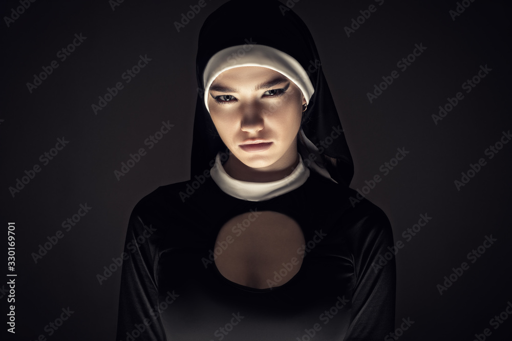 Wall mural gloomy portrait of a young nun closeup