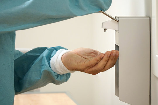 Doctor sterilizes his hands for hygiene and against hospital germs and virus such as corona or influenza