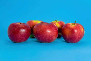 Ripe red red apples close-up isolate on a blue background.
