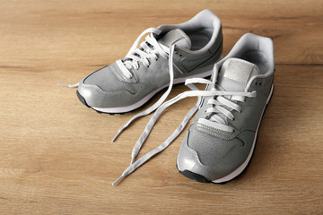 New gray sneakers on a light wooden background
