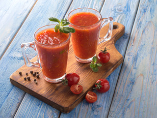 tomato juice in a glass cup on a wooden board.