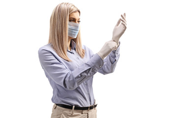 Young woman with a medical face mask putting on surgery gloves