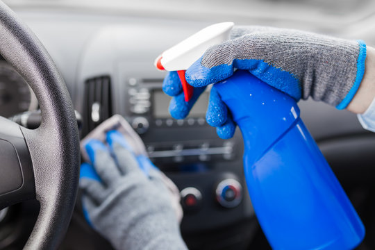 Close Up Of Man Hands Using Microfiber Cloth And Spray Bottle While Cleaning Car Interior.