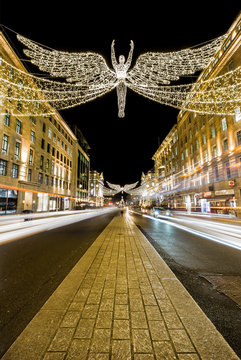 London, England/Britain December 31 2019 - long exposure shot of the Regent Street Christmas lights with the angel soaring into the sky and light trails from vehicles passing each side of the image
