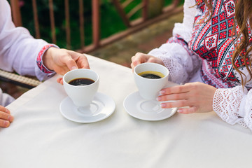 closeup of hot coffee cups in hands of newlyweds. cafe.