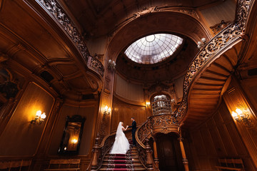 Obraz premium the groom holds the bride by the hand and they climb on wooden c