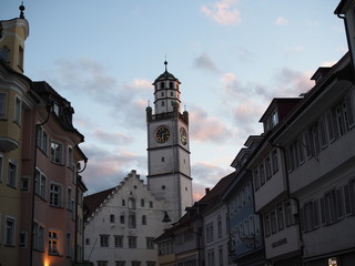 Fototapeta premium cityscape of an old town with tower against clouds at sunset