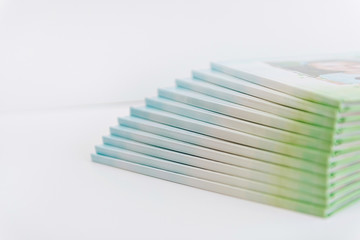 a large stack of blue-green books lies on a white surface. finished products of printed photobooks on a light background