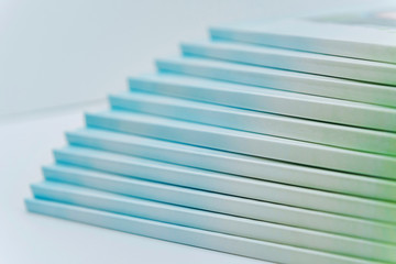 a large stack of blue-green books lies on a white surface. finished products of printed photobooks on a light background