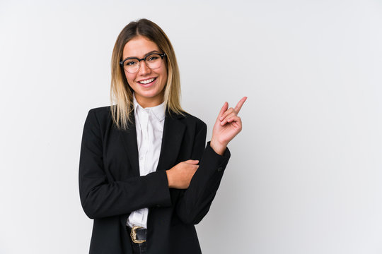 Young business caucasian woman smiling cheerfully pointing with forefinger away.