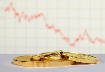 Gold coins on the background of the decline chart. Selective focus. 
