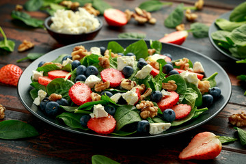 Spinach, Strawberry, blueberry salad with walnut and feta cheese. Summer healthy food