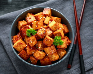 Fried Tofu in a bowl with chopstick and sesame seeds