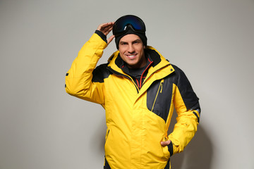 Man wearing stylish winter sport clothes on light grey background