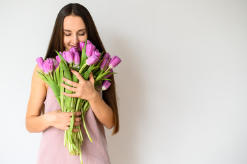 Spring mood. Beautiful woman with tulips indoors