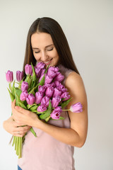 Spring mood. Beautiful woman with tulips indoors