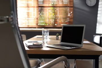 Laptop on wooden table in modern office