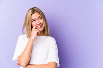 Young blonde caucasian woman isolated relaxed thinking about something looking at a copy space.