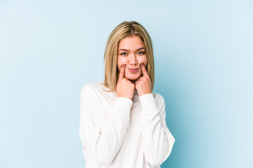 Young blonde caucasian woman isolated doubting between two options.