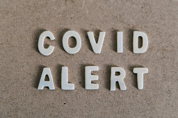 "Covid Alert" word on a wooden background. Coronavirus pandemic. 