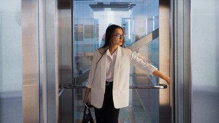 Charming young business lady in the Elevator in the business center. A young woman © Ulia Koltyrina