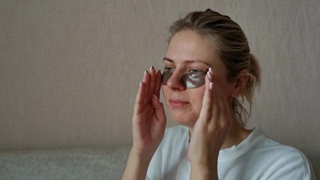 a young beautiful girl with black eye patches. morning facial treatments.