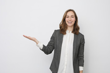 Beautiful businesswoman is looking happy and presenting your product