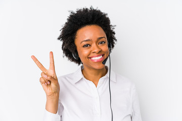 Young african american telemarketer woman isolated joyful and carefree showing a peace symbol with...