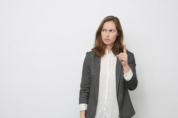 Businesswoman is pointing up while looking mad