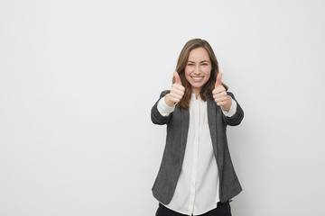 Businesswoman is pointing the thumb up while looking hopefull