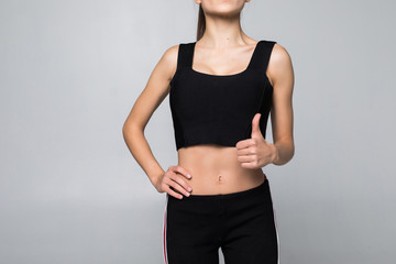 Happy fitness woman showing thumb up isolated on a white background