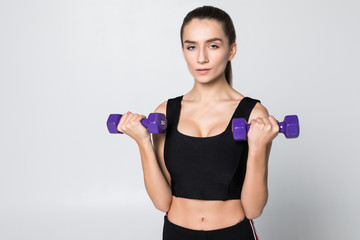 Smiling fitness woman workout with small dumbbells isolated on a white background