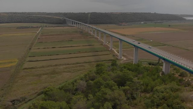 Cars on a concrete bridge over agricultural fields of mirna river valley. Aerial of Istria, Croatia