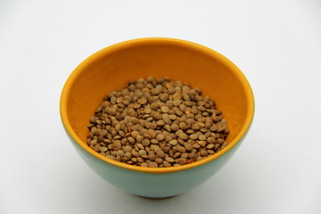 Ceramic bowl with lentils on a white background, top view