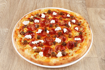Pepperoni pizza with vegetables on a wooden background - salami