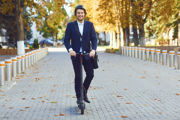 Young man in a helmet rides an electric scooter on a city street in summer © Studio Romantic