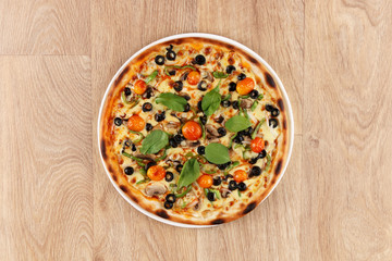veggie pizza with vegetables on a wooden background