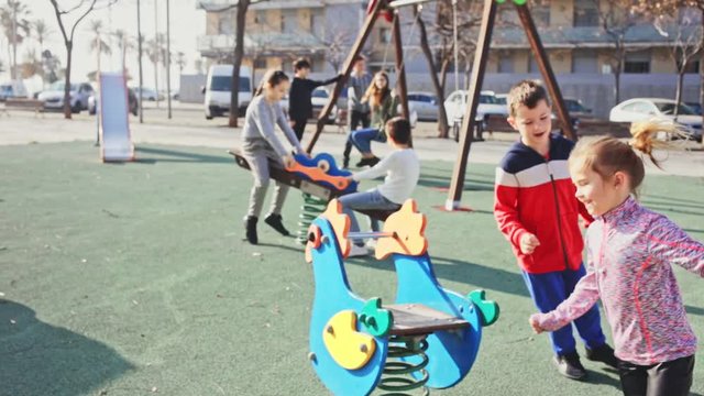 Smiling kids playing together on playground outdoors