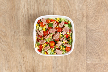 Tuna salad with fresh vegetables in a withe bowel  on a wooden background – Greece Salad