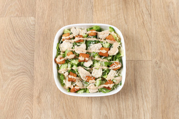 Caesar salad with fresh vegetables in a withe bowel  on a wooden background – Greece Salad