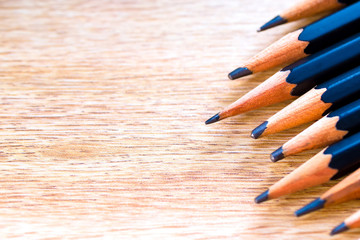 Obraz premium black pencils isolated on wood surface background.Close up.