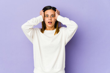 Young woman isolated on purple background being shocked, she has remembered important meeting.