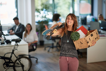 Work opportunity.Woman with stuff box leaving office building.