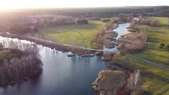 Miejski park z jeziorem i mostkiem nagrany z drona.