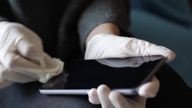 Close up of hands with gloves cleaning and disinfecting the phone. Germs, bacteria, Coronavirus, Covid-19, Contamination, Obsessive&ndash;compulsive disorder