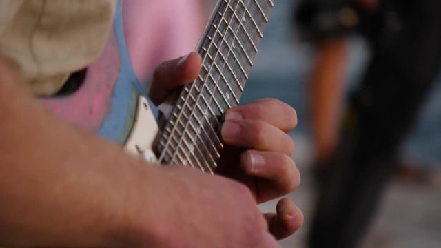 Musician fingers move across fingerboard of electric guitar. Chords for music. Close up shot