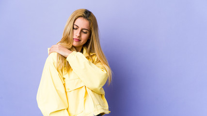 Fototapeta premium Young blonde woman isolated on purple background having a shoulder pain.